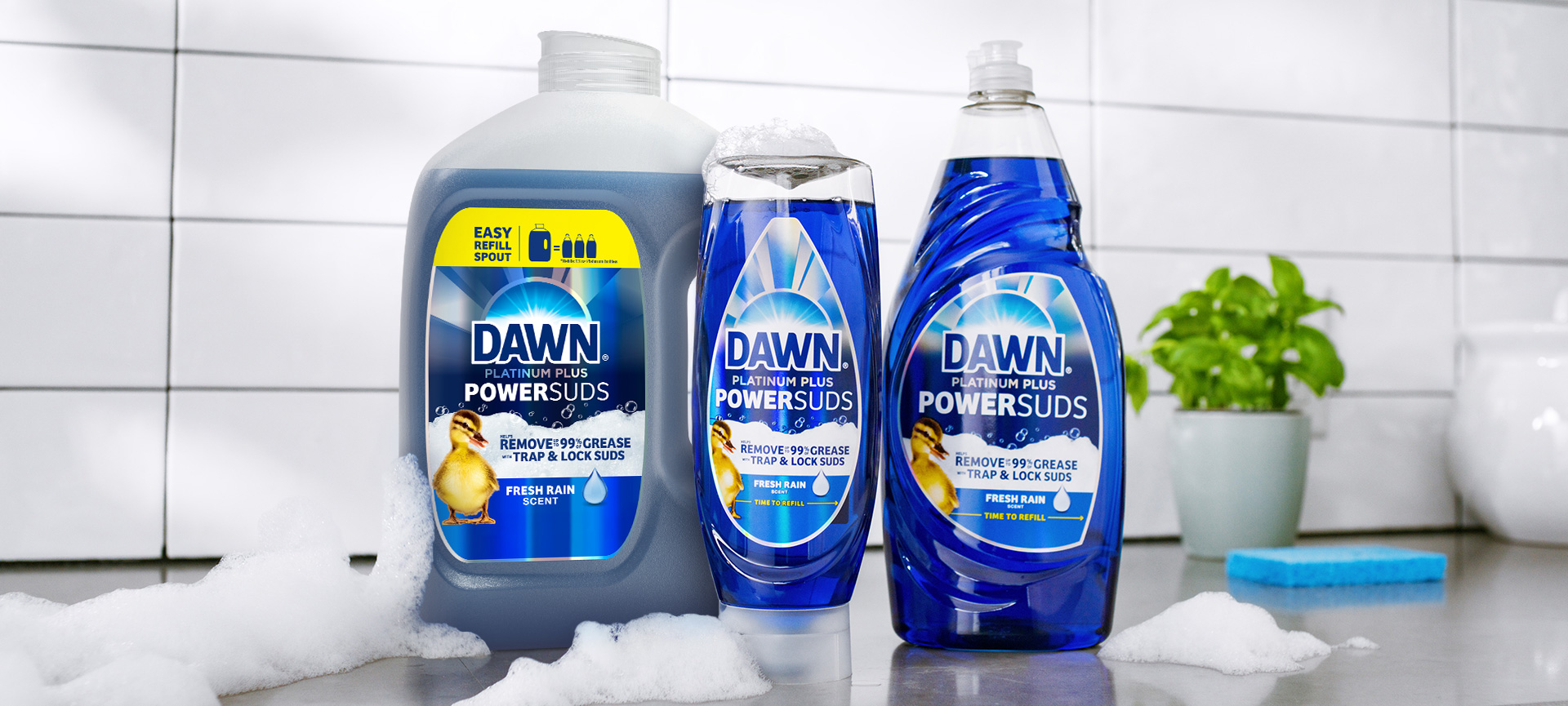 PowerSuds products on a white surface with foam around them, in the background of a white tile and flower