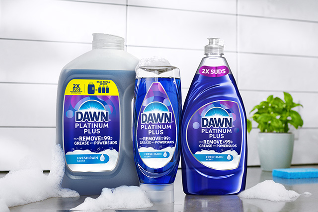 PowerSuds products on a white surface with foam around them, in the background of a white tile and flower