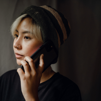 Une personne aux cheveux blonds d’origine asiatique qui parle au téléphone