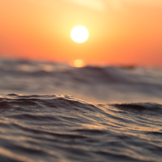 A body of water with a sunset behind it