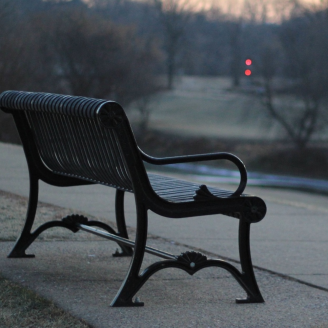 An empty bench in a grey park