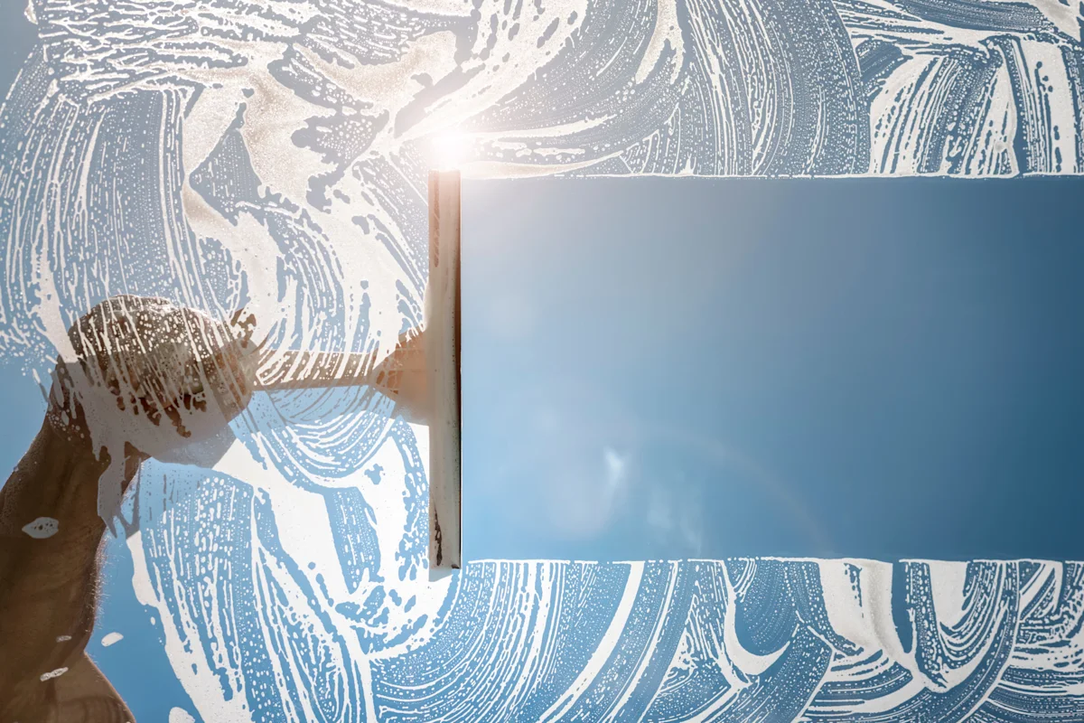 Cleaner using squeegee to wash window