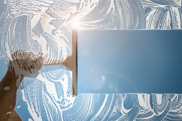 Cleaner using squeegee to wash window