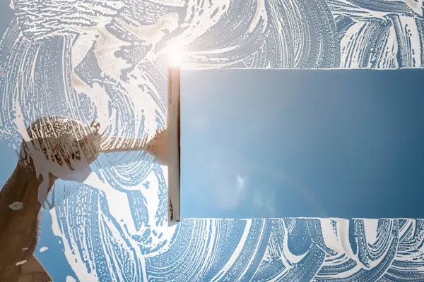 Cleaner using squeegee to wash window