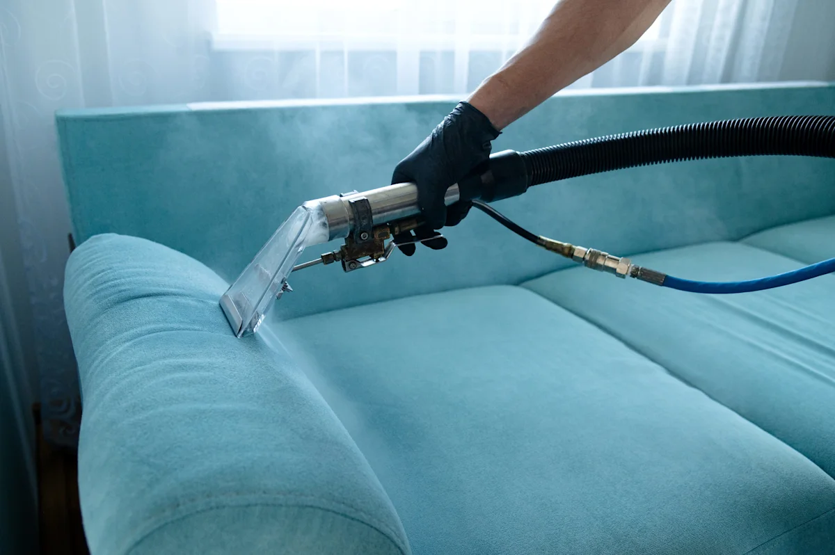 Close up of vacuum cleaning sofa