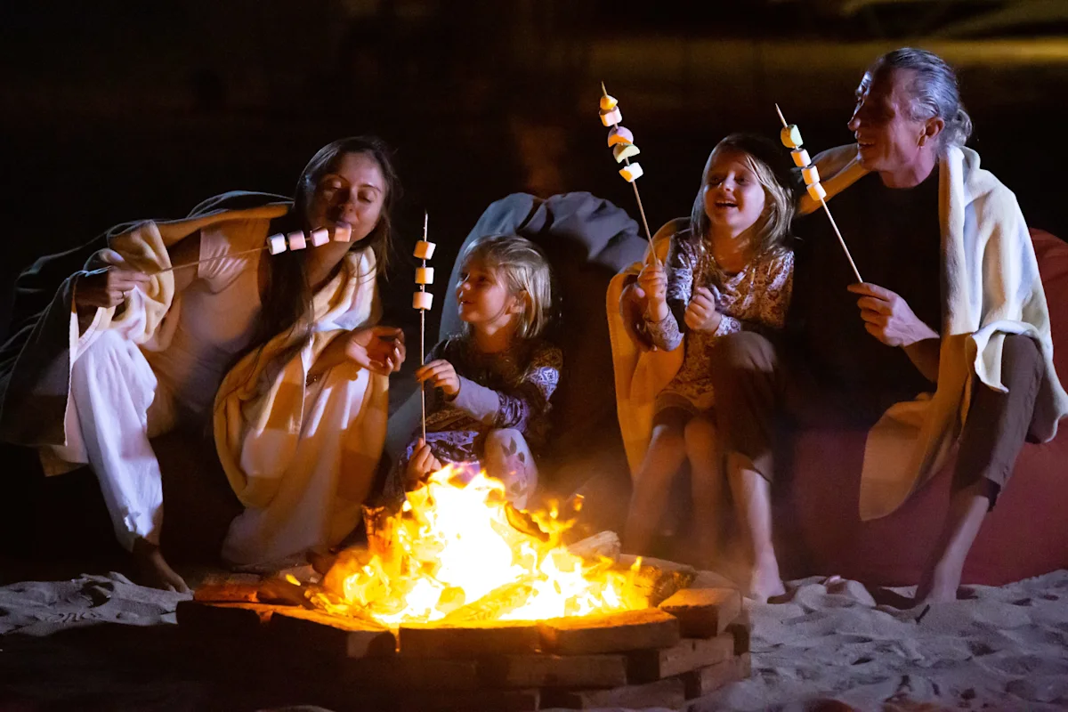 family roasting marshmallows around a bonfire