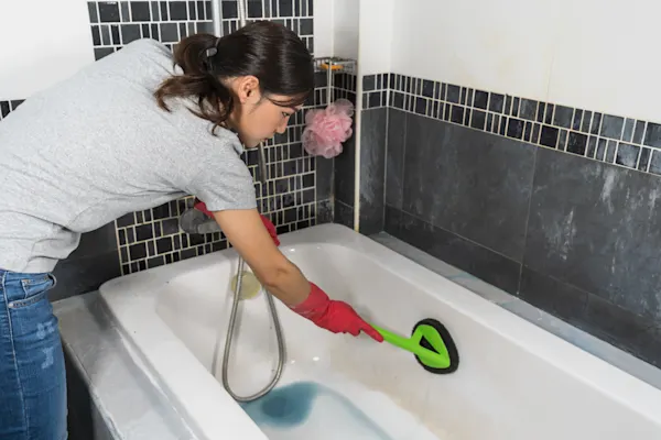 woman cleaning a bathtub