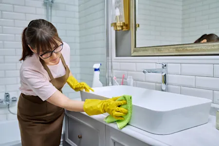 Woman cleaning bathroom sink