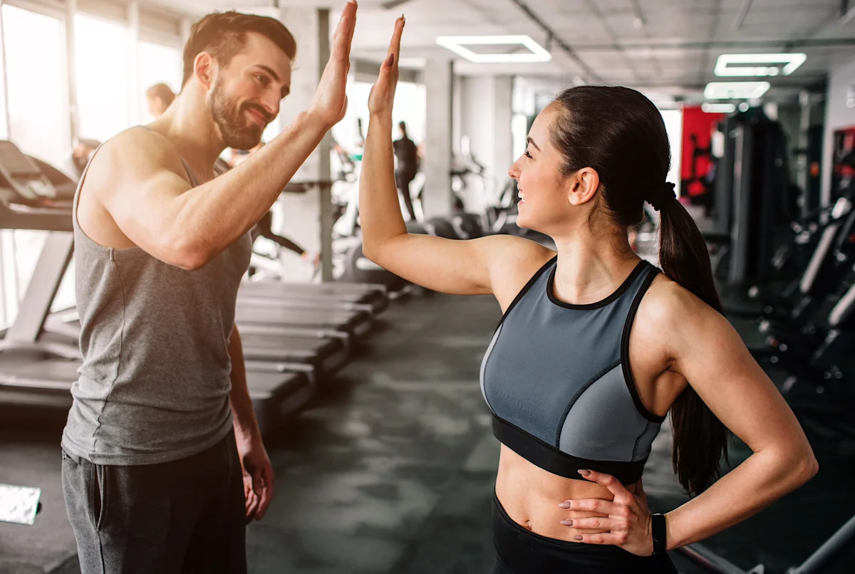 happy people at a gym going in for a high five