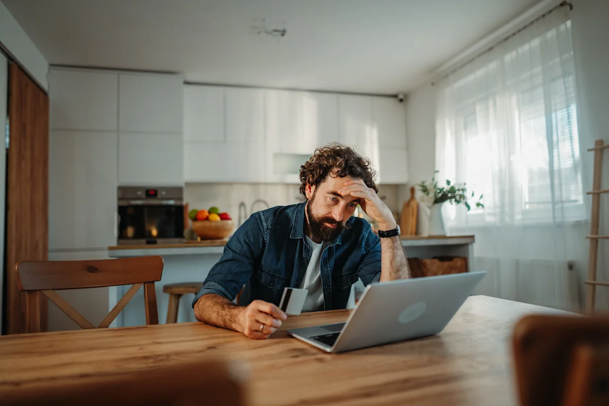 man looking frustrated sitting in front of laptop