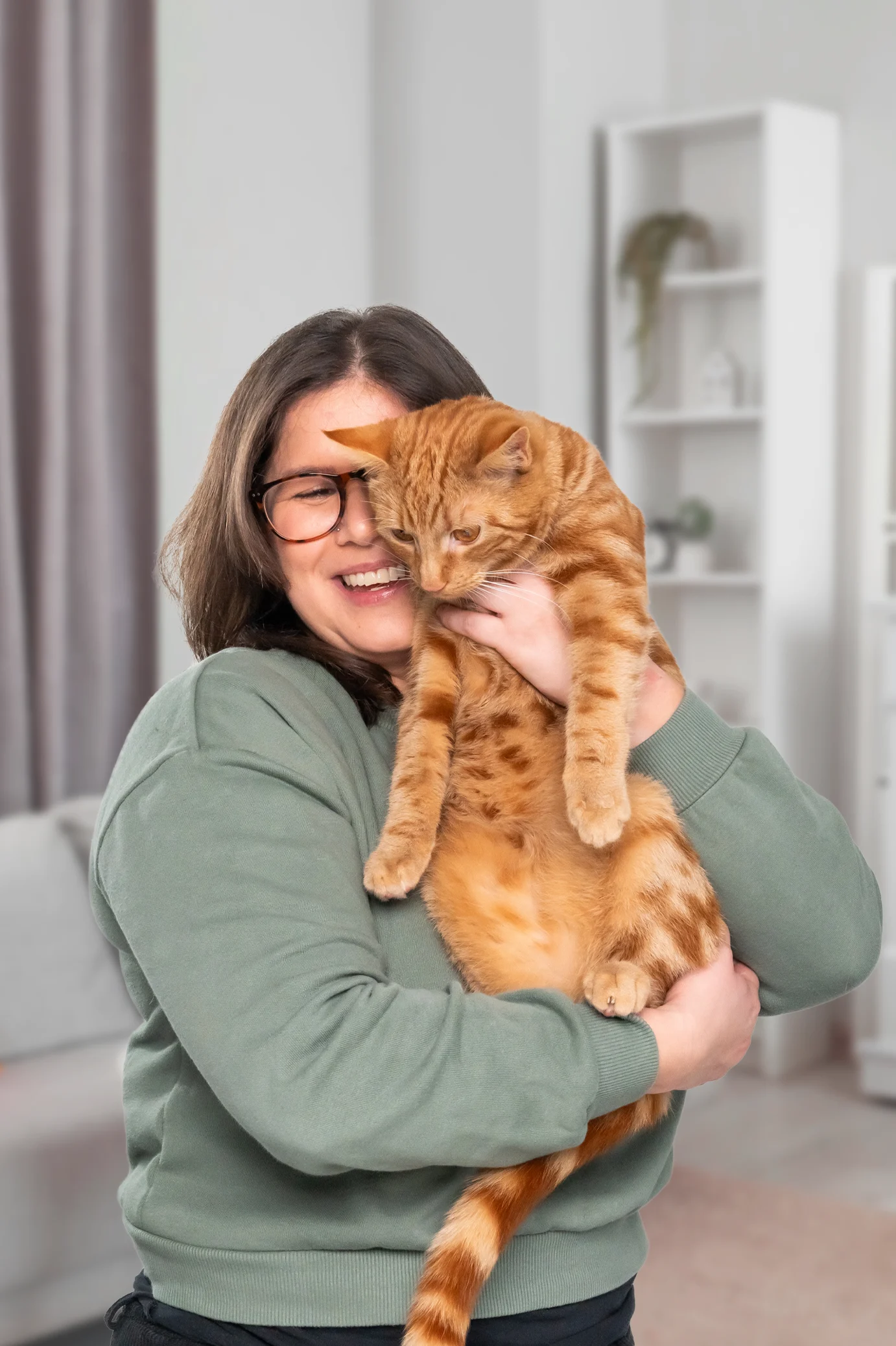 Young woman holding a ginger cat
