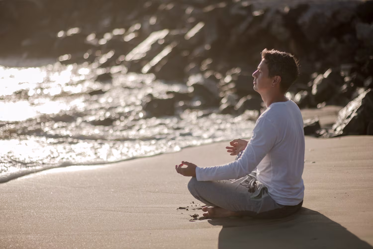 Foto di uomo che fa meditazione in spiaggia