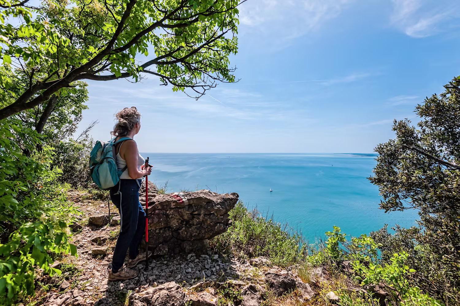 Foto di donna su un sentiero di trekking vista mare 