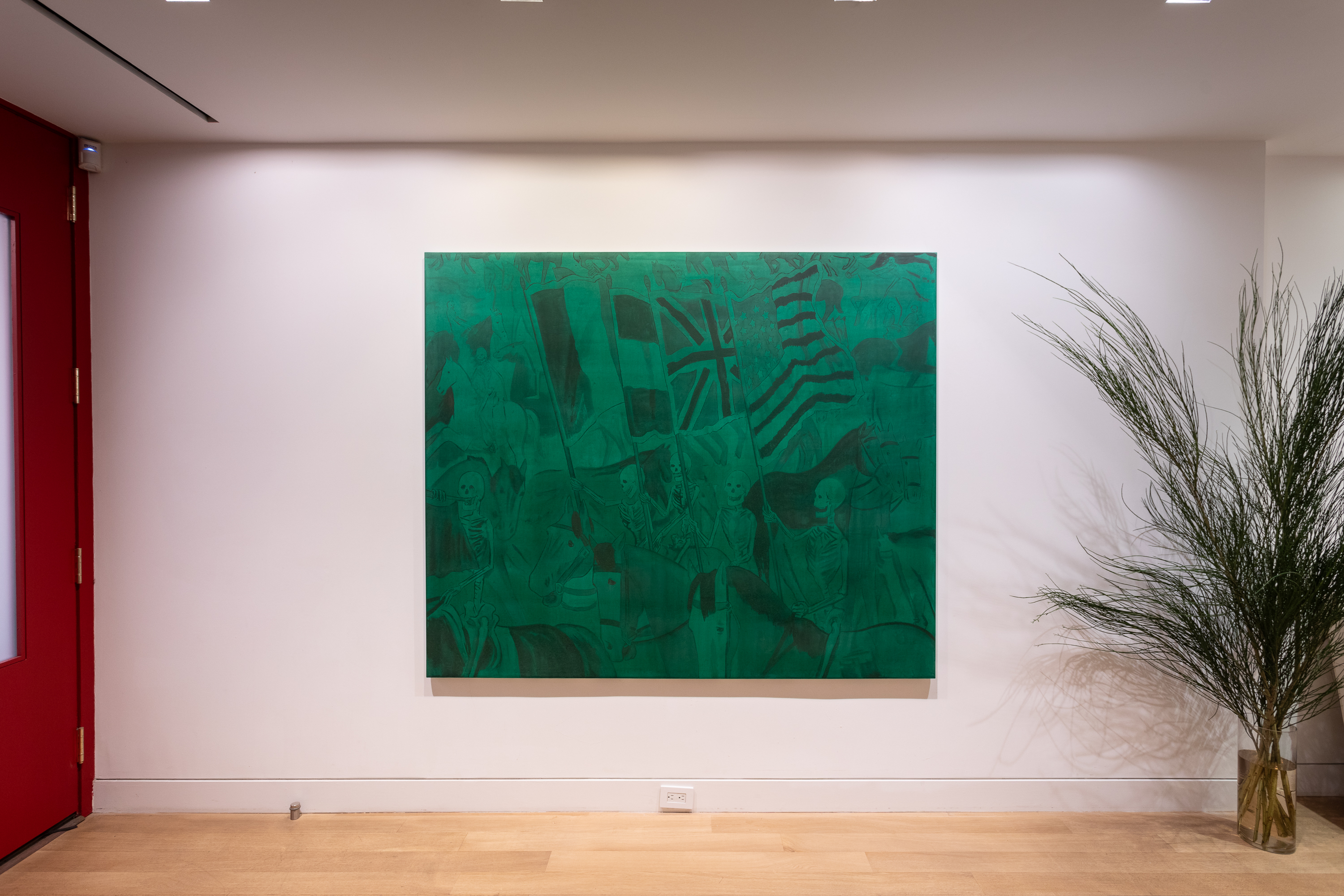 room with red door at left, green painting on white wall, and plant at right