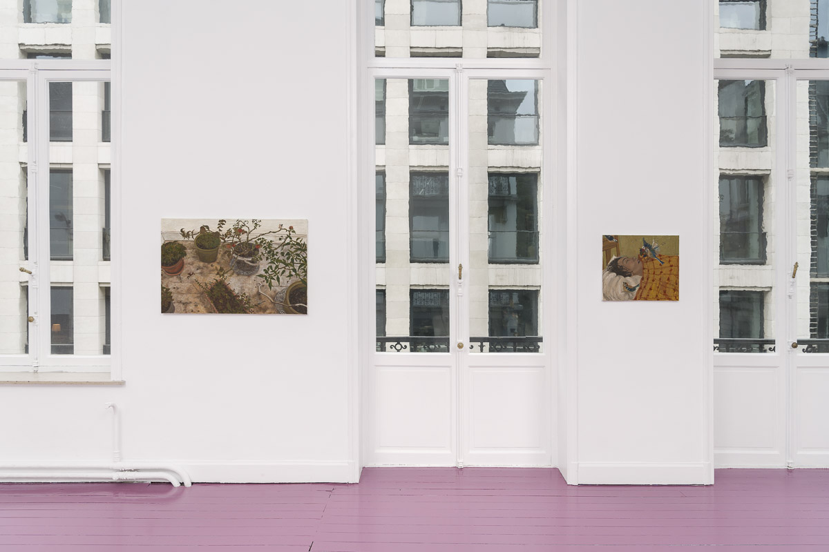 white room with pink wooden floor and two paintings on the wall