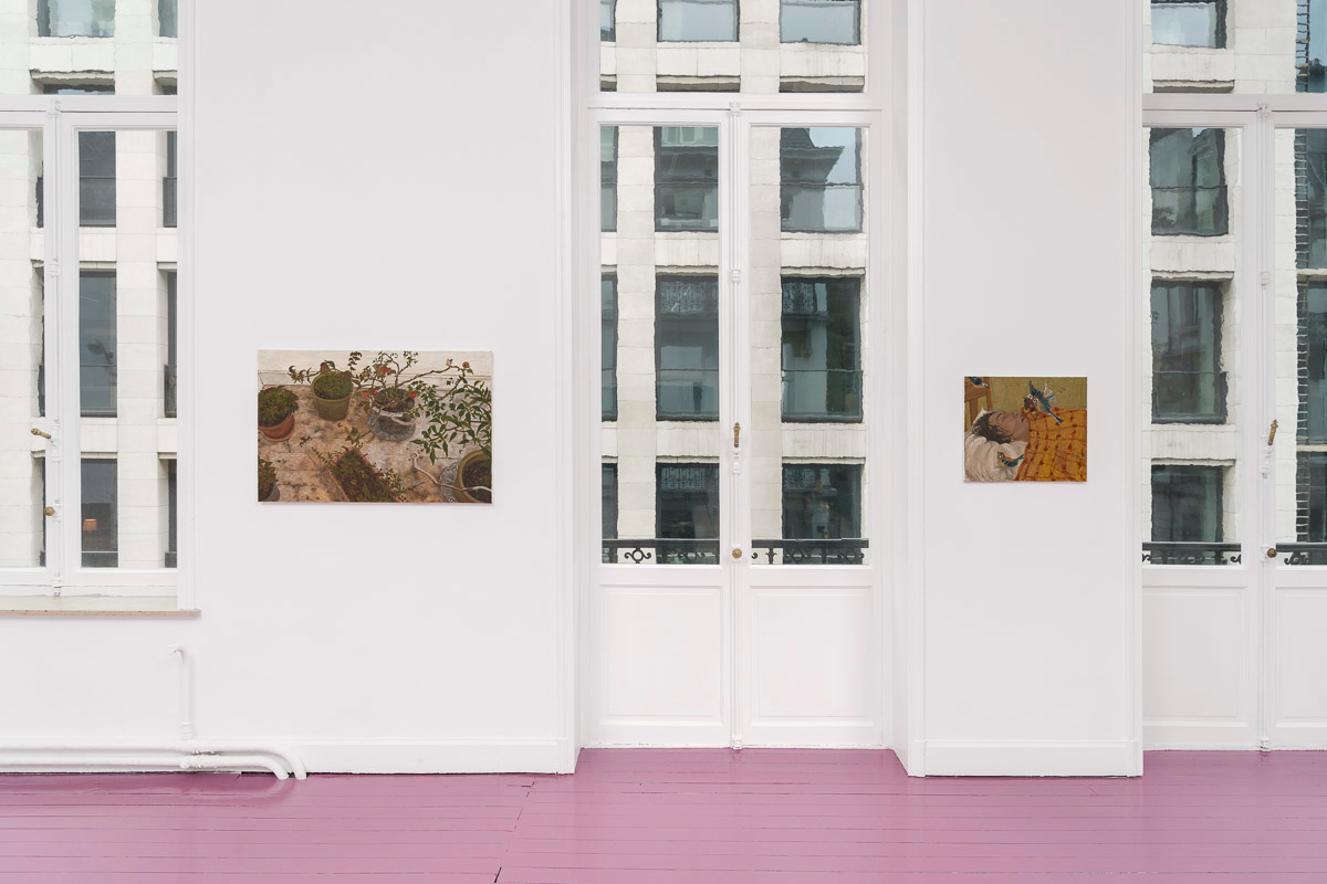 white room with pink wooden floor and two paintings on the wall