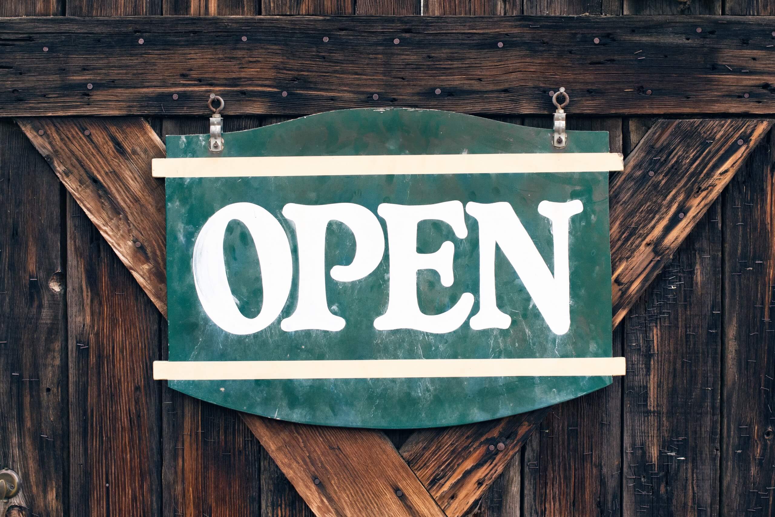 An open sign on a wooden door