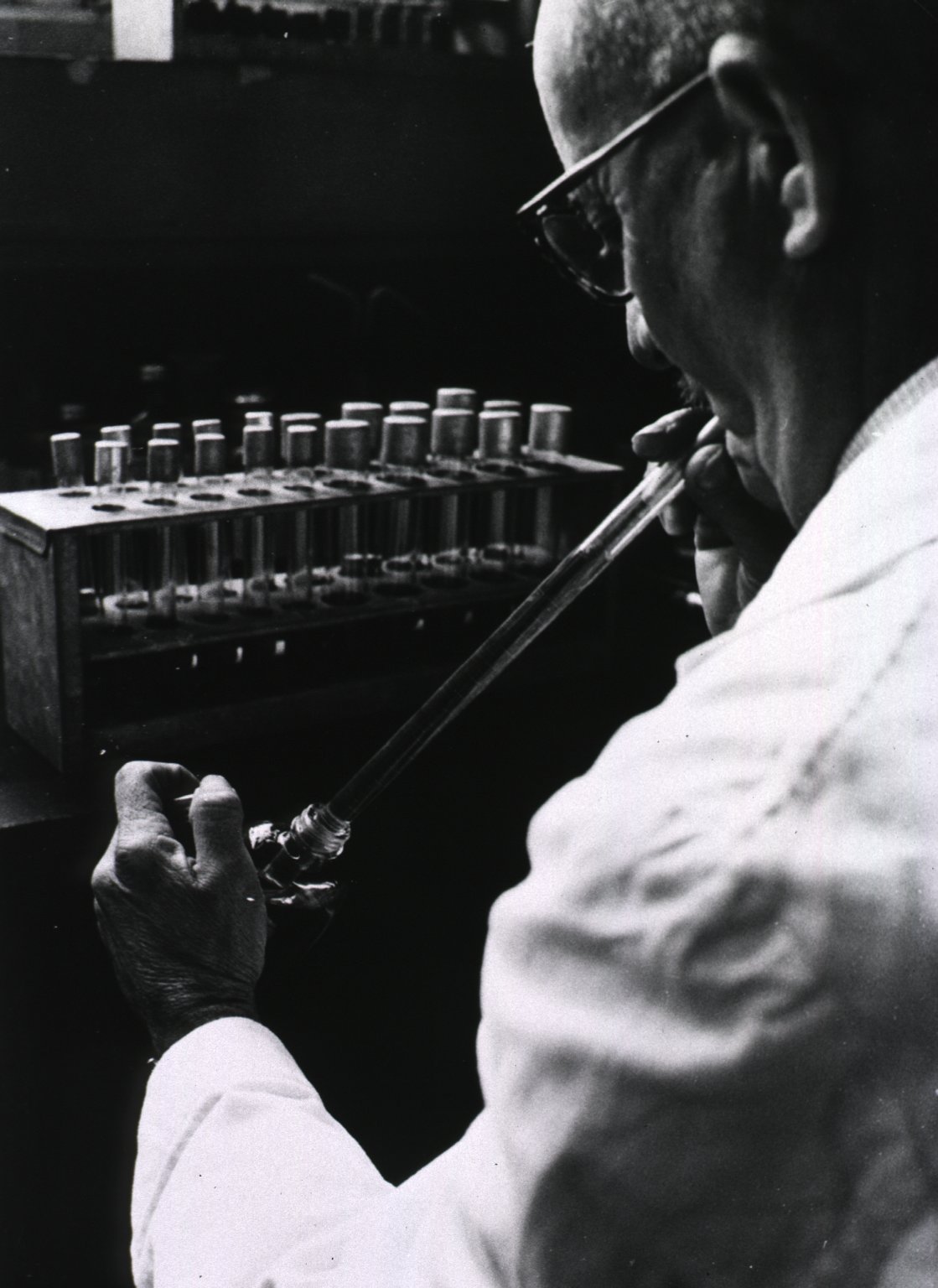 A techician mouth-pipetitng environmental water samples in Malta. Image: E Mandelmann. Source: History of Medicine