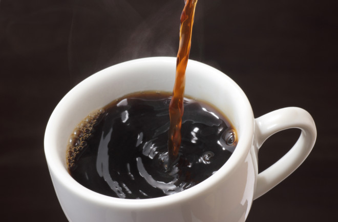 pouring black coffee in a white mug - shutterstock