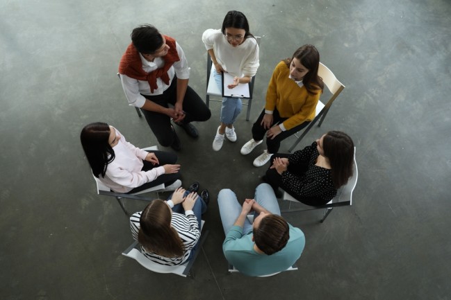 People sitting in a circle during group therapy