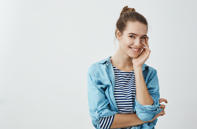 Woman Touching Face - Shutterstock