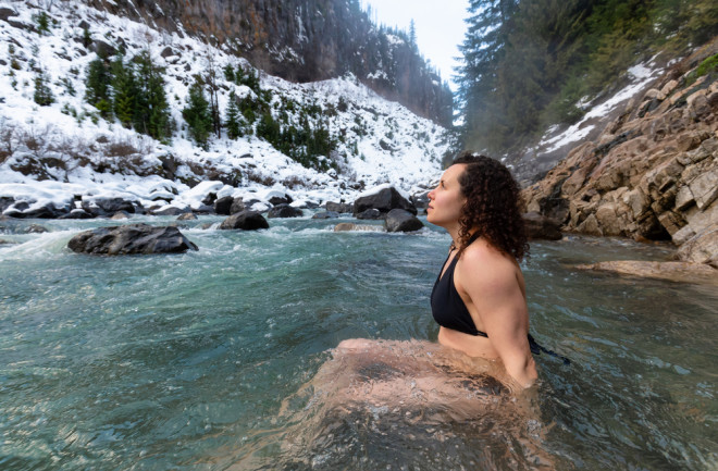 cold water plunge woman in a mountain lake with snow