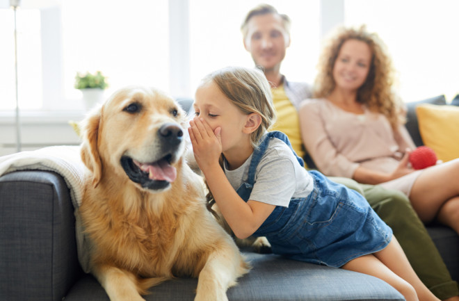 girl whispering to dog