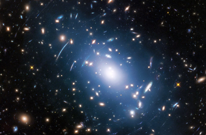Intracluster light (blue) in the galaxy cluster Abell S1063. One new technique uses intralight, imaged by Hubble, to map and study dark matter. (Credit: NASA, ESA, and M. Montes (University of New South Wales, Sydney, Australia) 