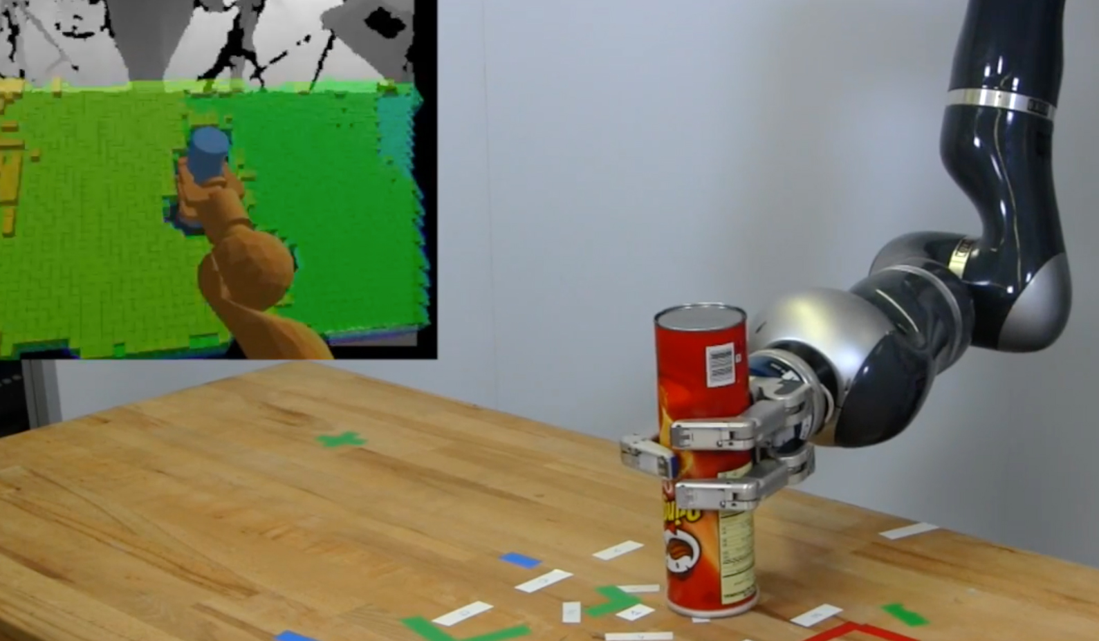 Apollo, a robot built by engineer Jeannette Bohg, tries to move a cylinder across a table while a cardboard box blocks its way. In this experiment, a researcher shifted the box to new locations on the table as the arm moved, forcing Apollo to recalculate its trajectory on the fly. The jumbled image in the lower right corner shows a view from Apollo’s perspective, underscoring just how hard it is for a robot to recognize and interact with objects around it.