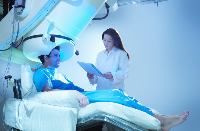 Doctor and patient using magnetoencephalography (MEG) scanner