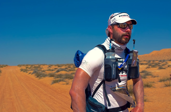 Runner competing in an ultra-marathon through Oman's Wahiba desert