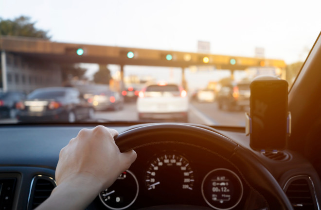 Hand on steering wheel while stuck in morning traffic 