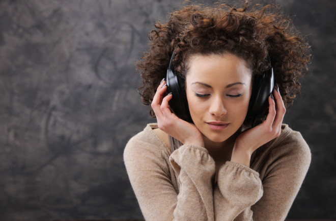 woman with headphones music and a sweater - shutterstock