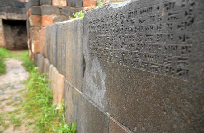 Cuniform inscription on the wall of Erebuni Fortress in Yerevan, Armenia - Shutterstock