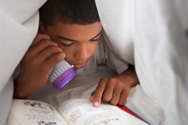Boy Child Reading in Bed Flashlight - Shutterstock