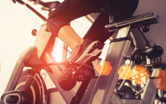 Person riding exercise bike, Fitness Metabolism - Shutterstock