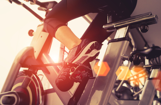 Person riding exercise bike, Fitness Metabolism - Shutterstock