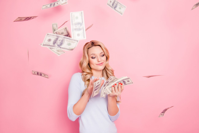 blonde-woman-making-it-rain-with-cash-pink-background