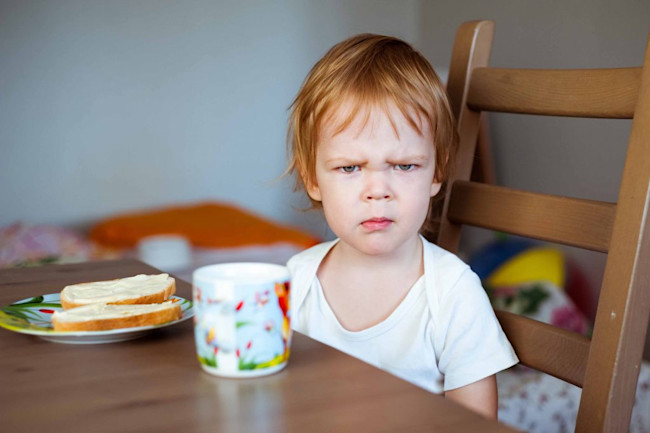 grumpy kid at table shutterstock