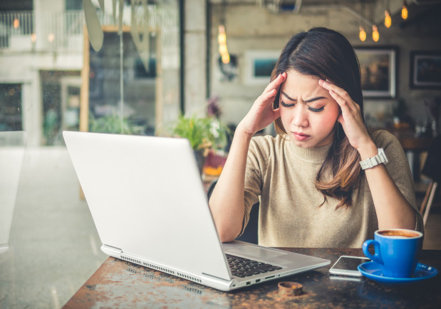 Woman trying to work but she is rubbing her head from Keto Brain Fog