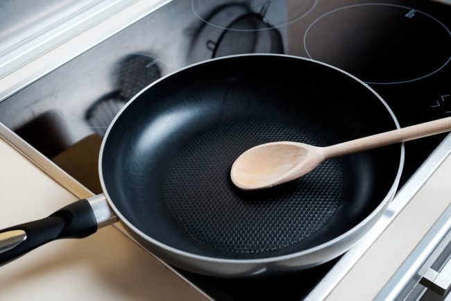 teflon nonstick pan wooden spoon induction burner - shutterstock 376168594