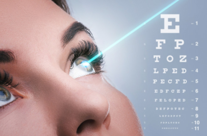 Female eye and laser beam during visual acuity correction with eye chart
