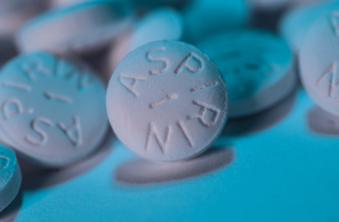 White aspirin tablets with blue background