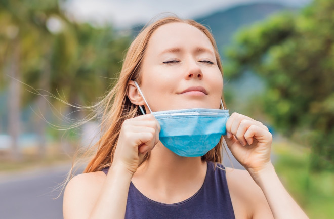 relief coronavirus deep breath woman take off mask - shutterstock