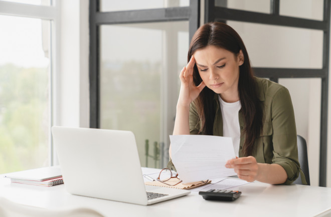 Woman stressed from looking at bills during a recession