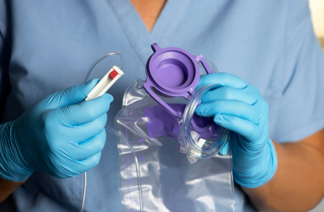 nurse holds enteral feeding bag Shutterstock
