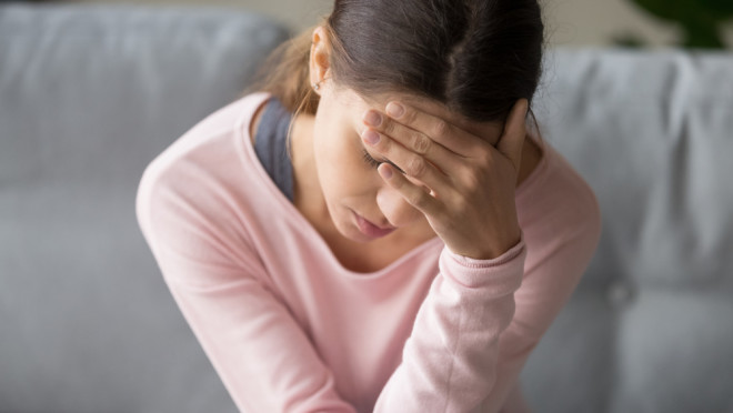 young woman - headache - pain - migraine - sick - illness - shutterstock