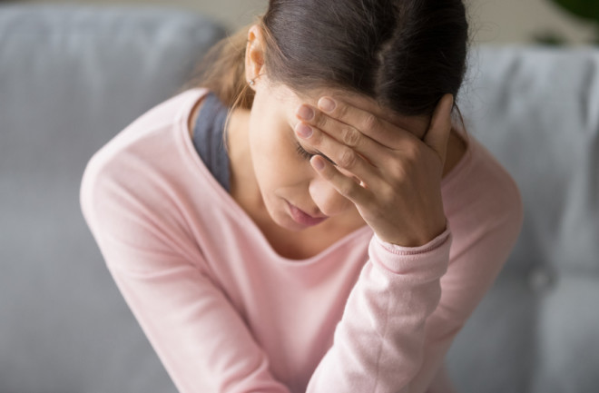 young woman - headache - pain - migraine - sick - illness - shutterstock