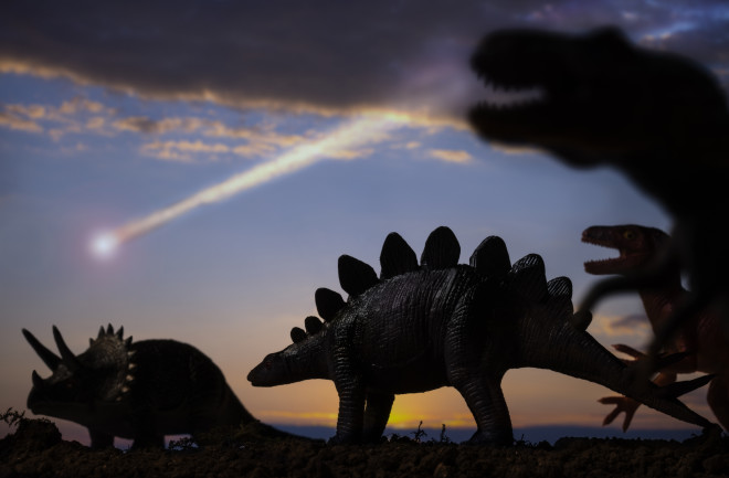 Dinosaurs and a meteor falling from the sky in back background.