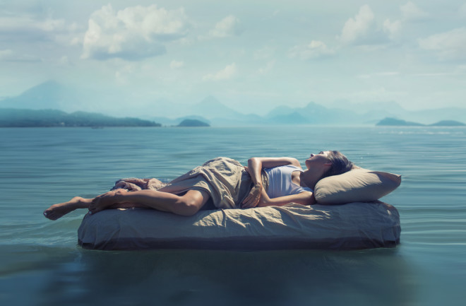 surreal dream bed in an ocean mountains dream interpretation - shutterstock